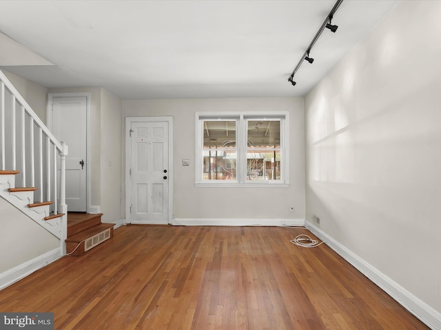 entrance foyer with stairs, wood finished floors, visible vents, and baseboards