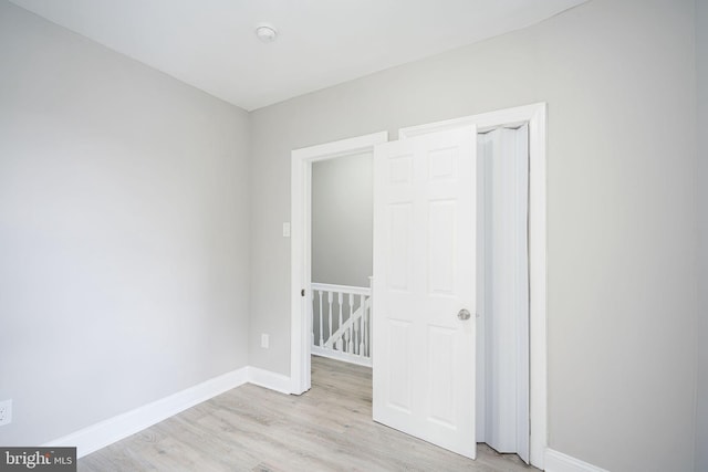 unfurnished bedroom with light wood-style flooring and baseboards