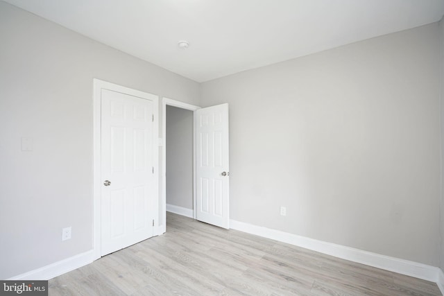 unfurnished bedroom with light wood finished floors and baseboards