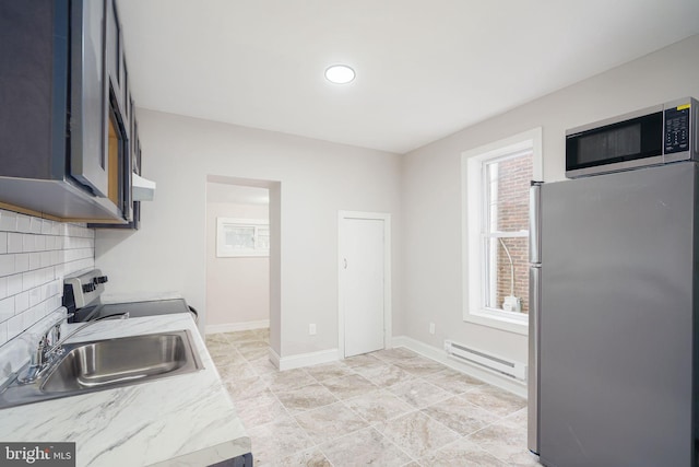 kitchen with a baseboard radiator, backsplash, stainless steel appliances, sink, and light tile patterned flooring