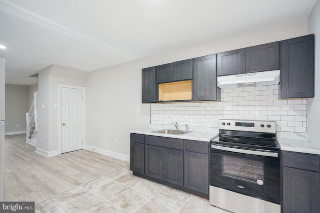 kitchen with backsplash, sink, stainless steel range with electric stovetop, light stone counters, and light wood-type flooring