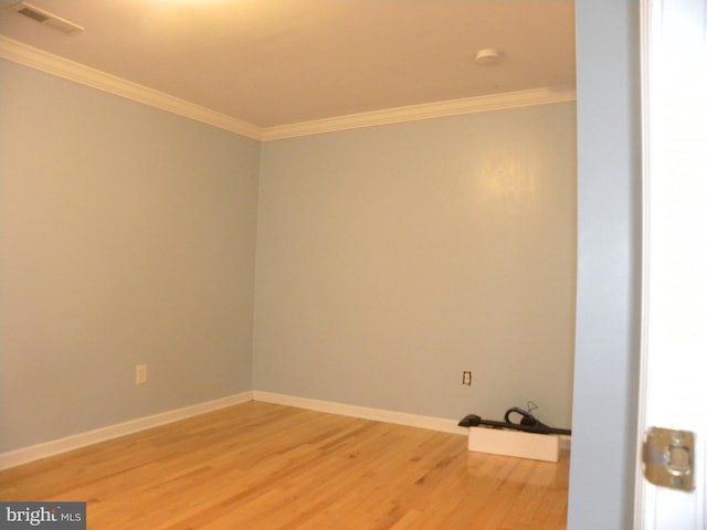 empty room with hardwood / wood-style flooring and ornamental molding