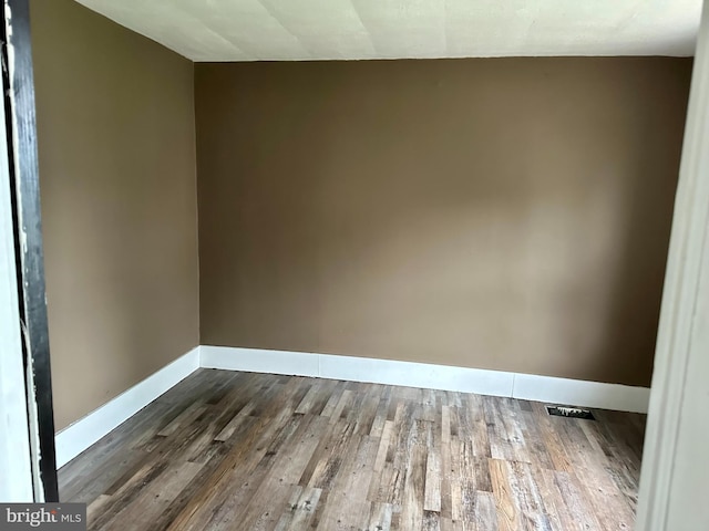 unfurnished room with wood-type flooring