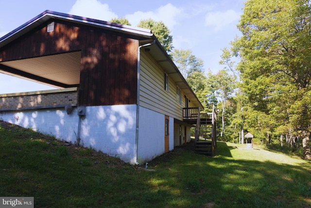 view of side of home with stairs, a lawn, and a wooden deck