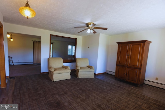 unfurnished room with baseboard heating, a textured ceiling, ceiling fan, and dark wood-type flooring