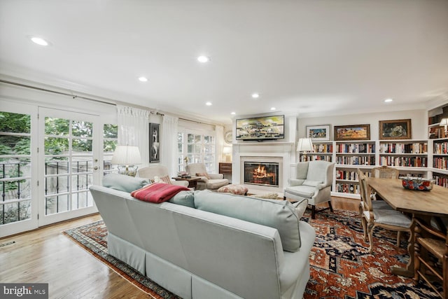 living room with light hardwood / wood-style flooring and crown molding