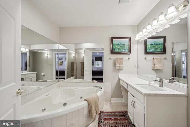 bathroom with tiled tub, tile patterned floors, and vanity