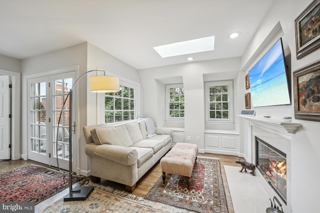 living room with hardwood / wood-style flooring, a healthy amount of sunlight, and a skylight