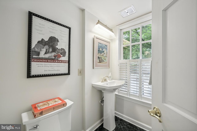 bathroom featuring sink, a wealth of natural light, and toilet