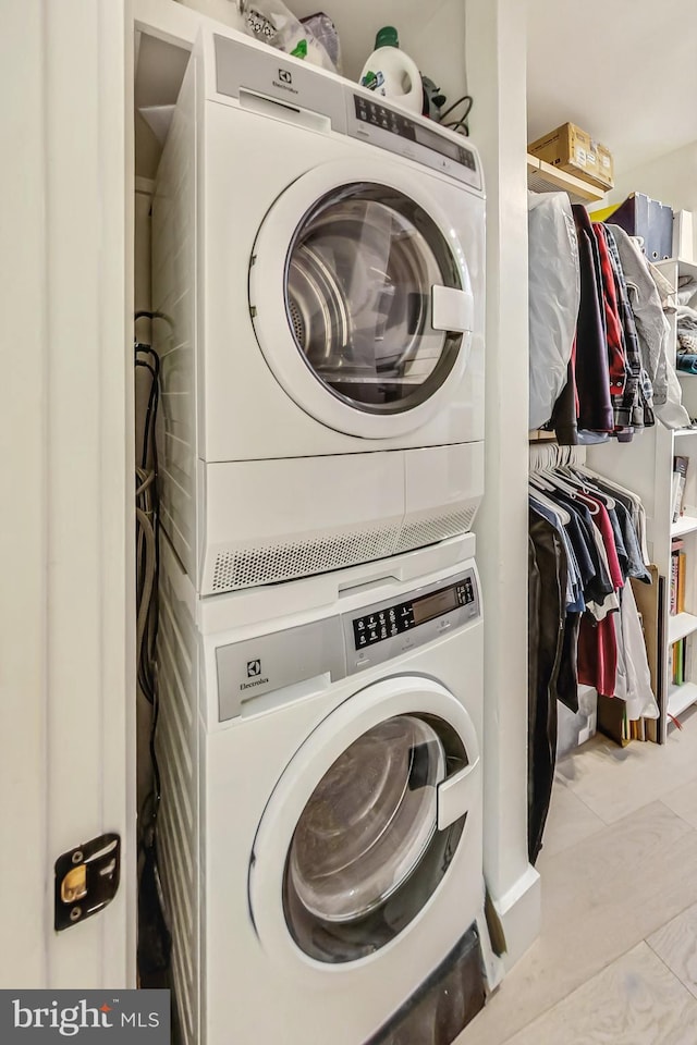 clothes washing area with laundry area and stacked washer / drying machine