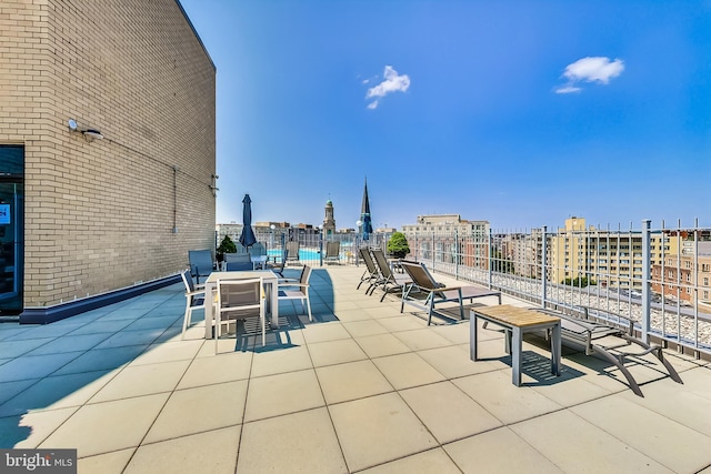 view of patio with a view of city and fence