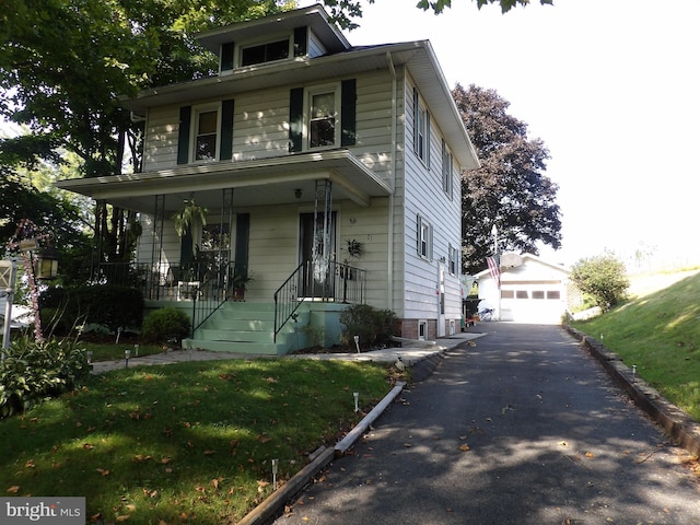 view of front of house with a front yard, a porch, and a garage