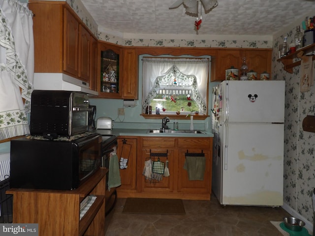 kitchen with ceiling fan, white refrigerator, sink, and dark tile patterned floors