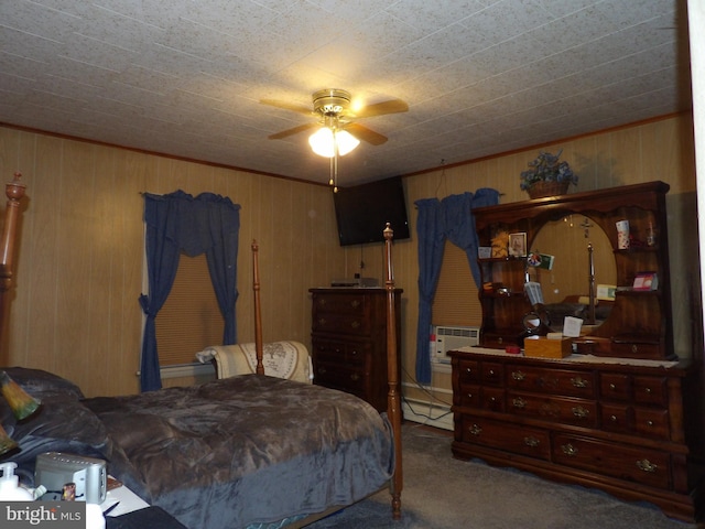 bedroom with ceiling fan, wooden walls, and carpet