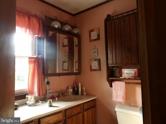 bathroom with crown molding, vanity, and toilet