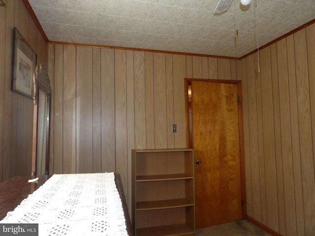 unfurnished bedroom featuring ceiling fan and wooden walls