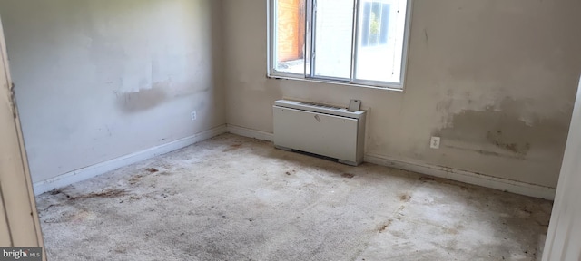 spare room featuring baseboards and radiator