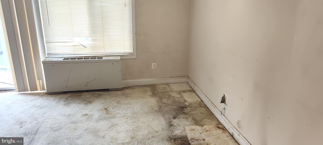 empty room featuring baseboards and radiator heating unit