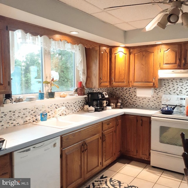 kitchen featuring light tile patterned flooring, tasteful backsplash, sink, white appliances, and ceiling fan