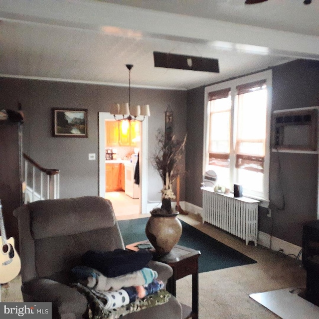 carpeted living room with radiator and a chandelier