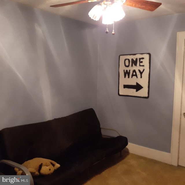 living area with carpet and ceiling fan