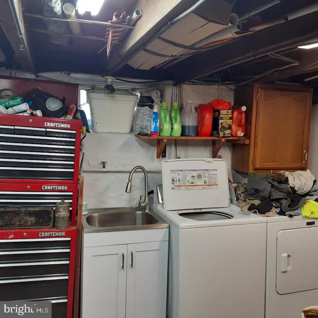 laundry room featuring cabinets, washing machine and dryer, and sink