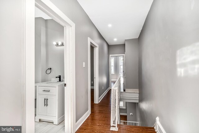 hallway with light hardwood / wood-style floors and sink