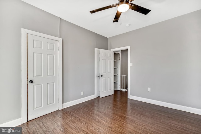 unfurnished bedroom featuring ceiling fan and dark hardwood / wood-style floors