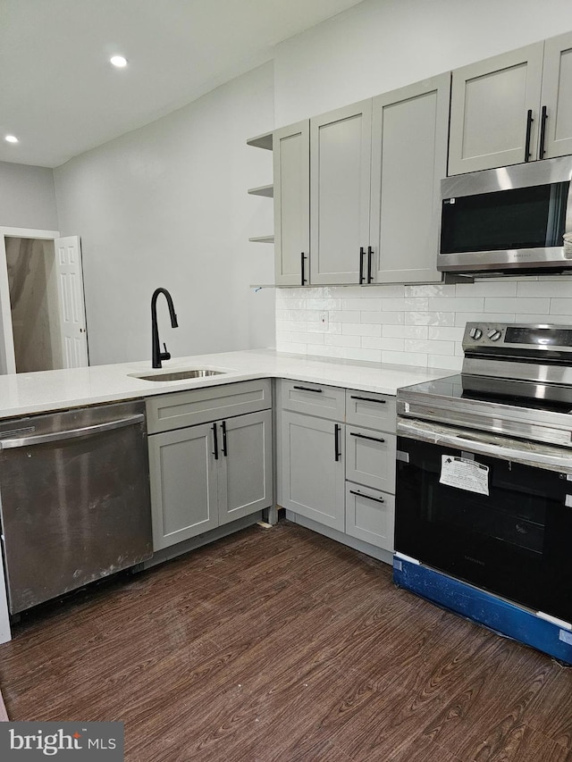 kitchen with gray cabinets, appliances with stainless steel finishes, sink, and dark wood-type flooring