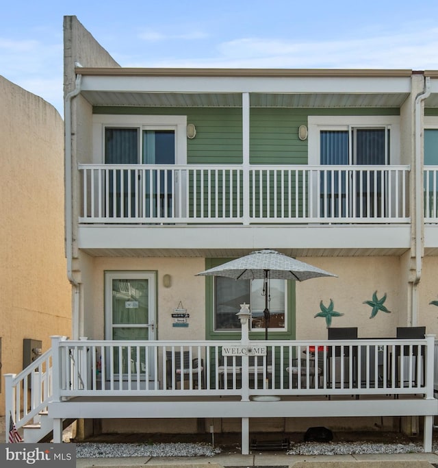 back of house with a balcony and stucco siding