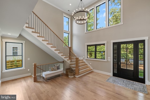 entrance foyer featuring light wood finished floors, recessed lighting, an inviting chandelier, baseboards, and stairs