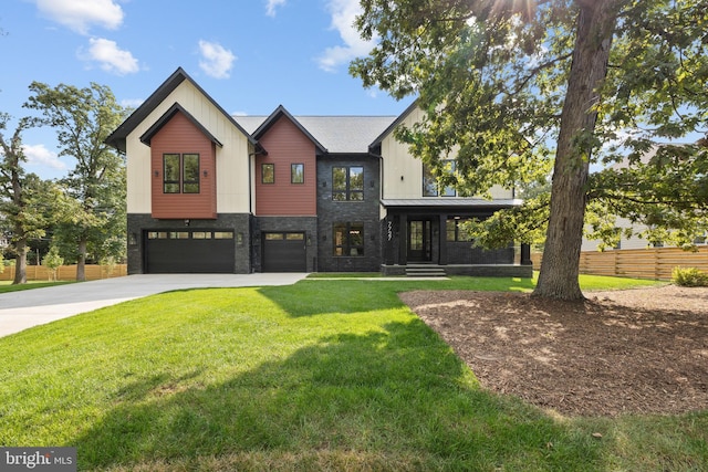 modern farmhouse featuring an attached garage, fence, stone siding, concrete driveway, and a front lawn