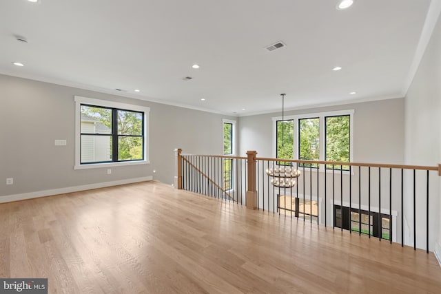 empty room featuring light hardwood / wood-style flooring and crown molding