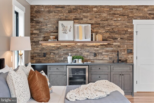 bar with gray cabinets, sink, light hardwood / wood-style flooring, and wine cooler