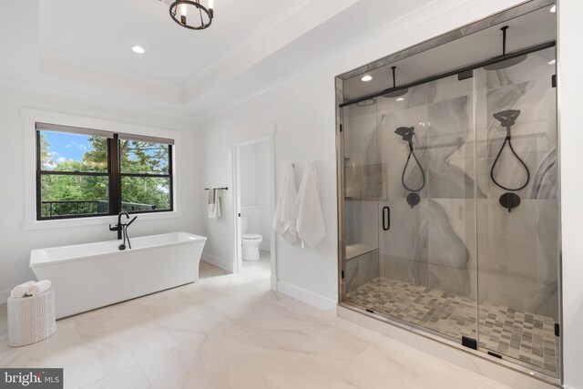 bathroom with plus walk in shower, a tray ceiling, ornamental molding, and toilet