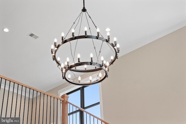 interior details with visible vents, a notable chandelier, and ornamental molding