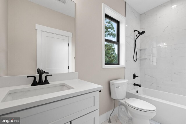 full bathroom with tiled shower / bath, vanity, and toilet