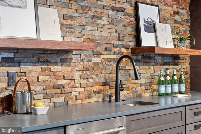 kitchen with gray cabinetry, stainless steel dishwasher, and sink