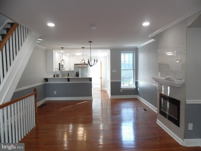 living room featuring an inviting chandelier, dark hardwood / wood-style floors, and crown molding