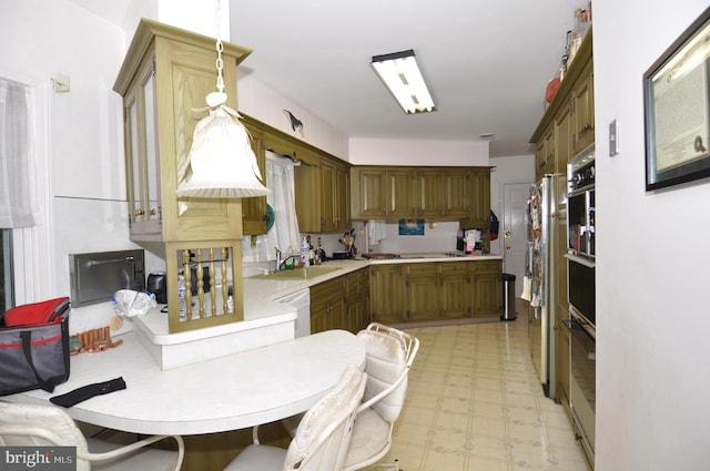 kitchen featuring white dishwasher, sink, and stainless steel fridge