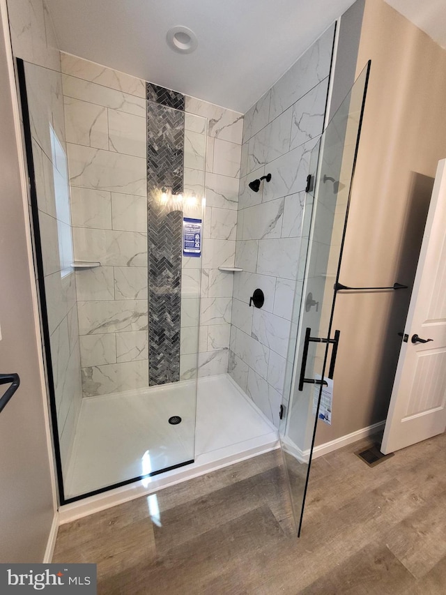 bathroom featuring a shower with door