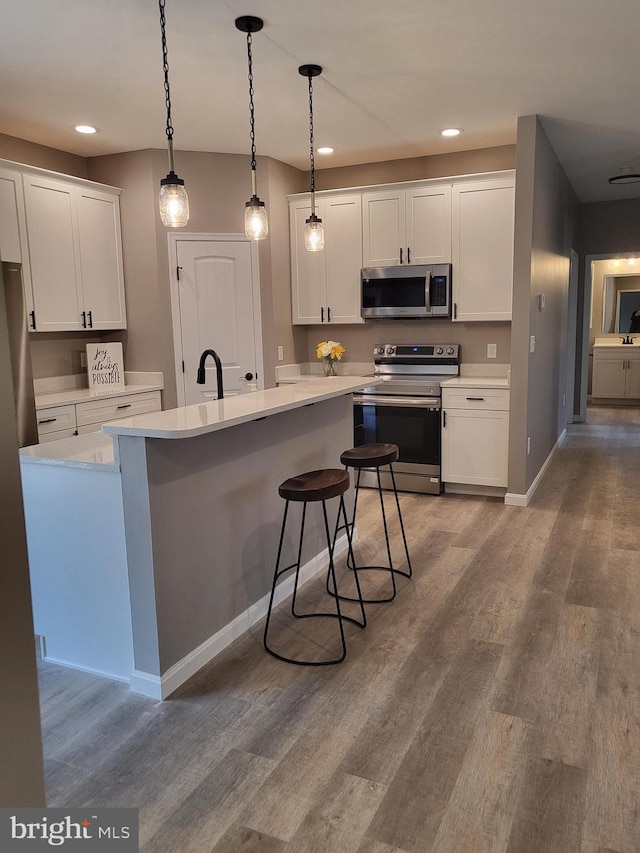 kitchen featuring stainless steel appliances, white cabinets, and light hardwood / wood-style floors