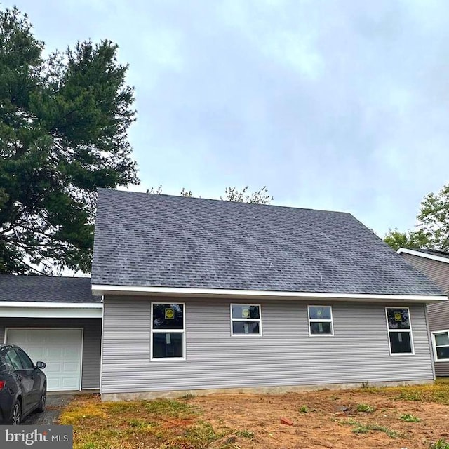 rear view of property with a garage