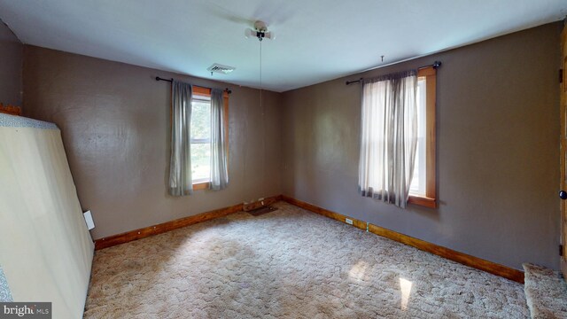 unfurnished room featuring visible vents, baseboards, and carpet