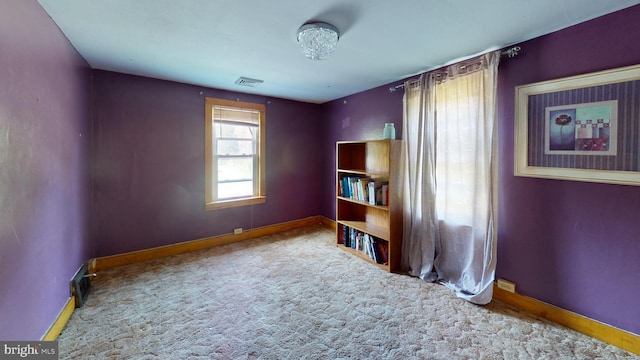 carpeted spare room featuring visible vents and baseboards