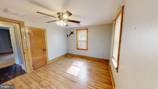 unfurnished bedroom with multiple windows, wood finished floors, and visible vents