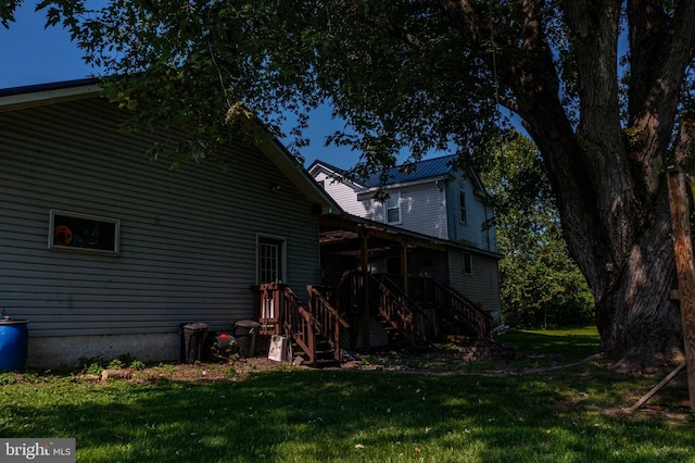 rear view of house with a yard and metal roof