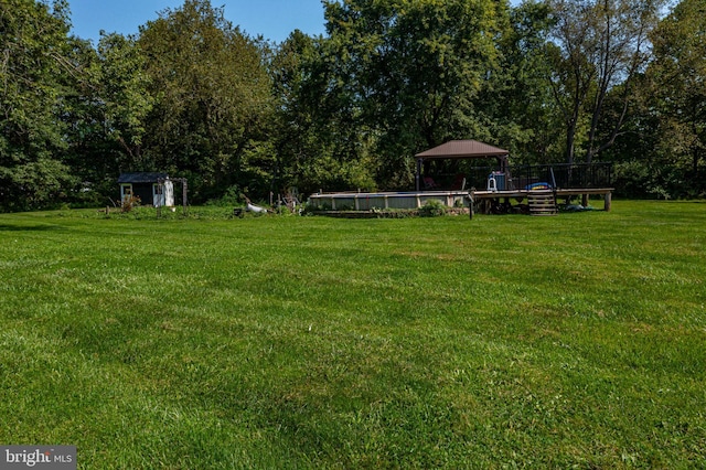 view of yard with an outdoor structure, a storage unit, and an outdoor pool