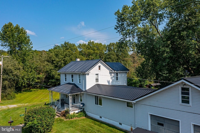 view of front of house featuring a porch, a front yard, metal roof, a garage, and crawl space