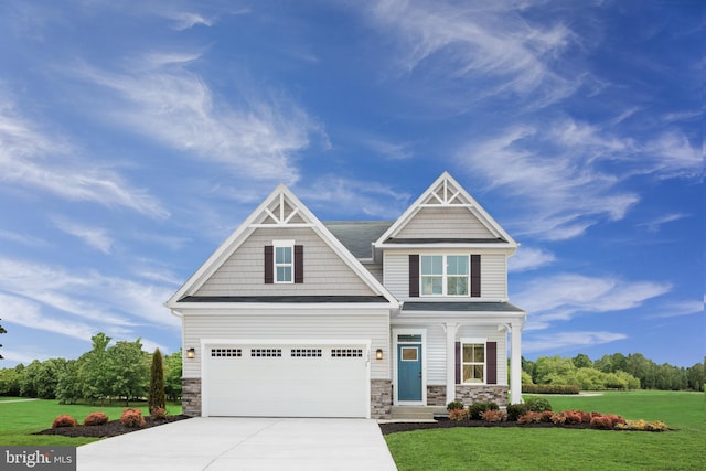 craftsman inspired home with a garage and a front lawn